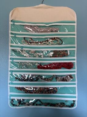 Various necklaces andTurquoise Hanging Jewelry Organizer with Clear Zip Pockets